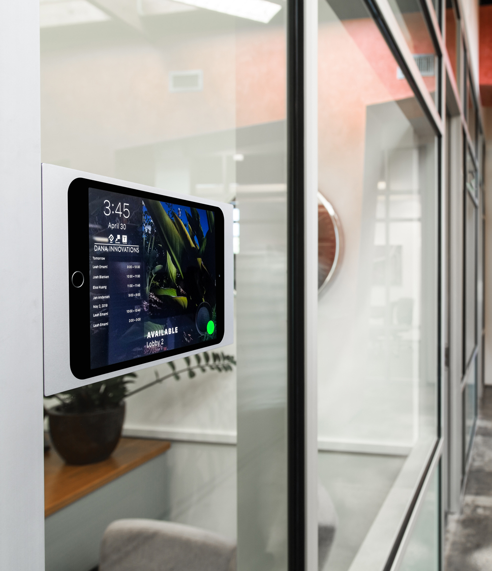 Silver iPad wall mount by IPORT used as a meeting room display. 