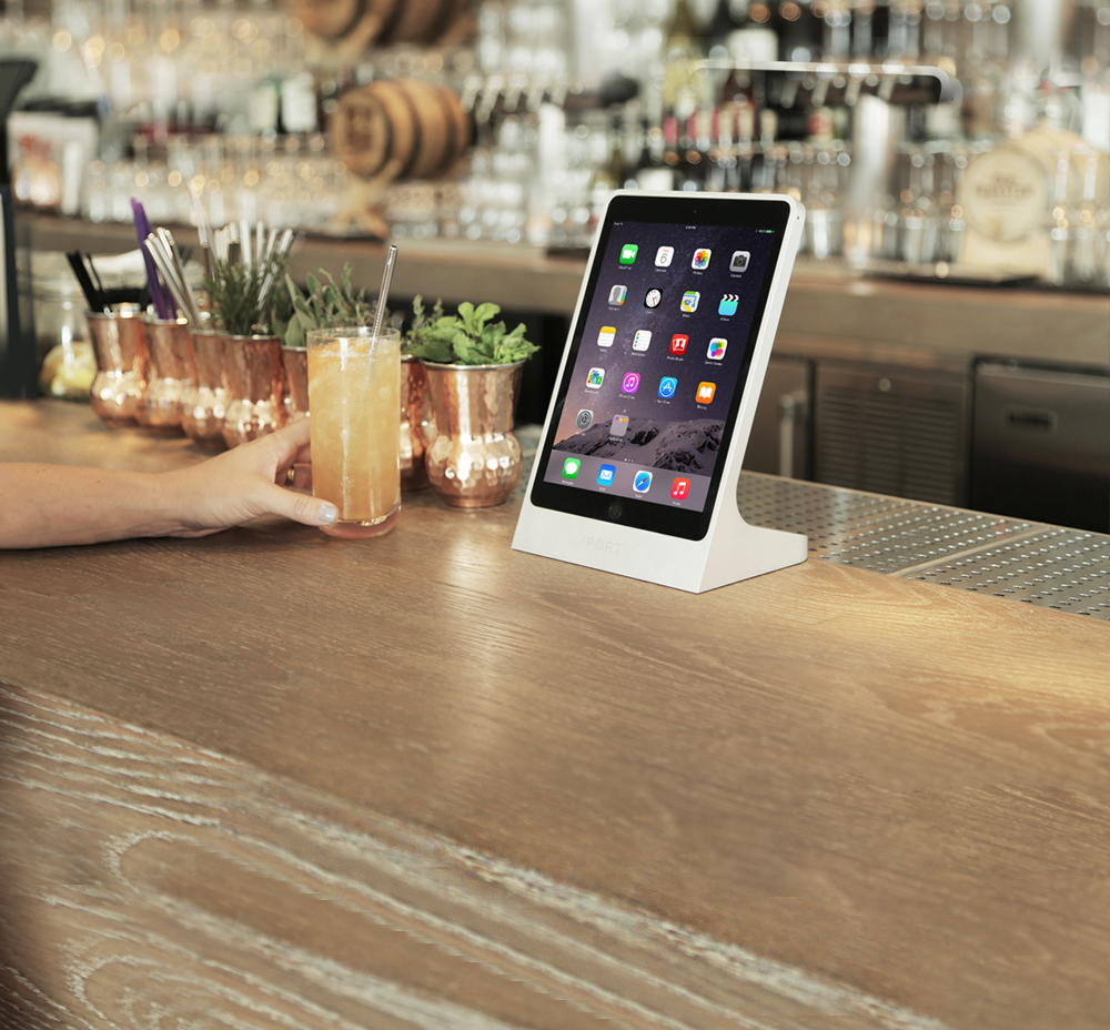Silver iPad stand for restaurants by IPORT on a bar.